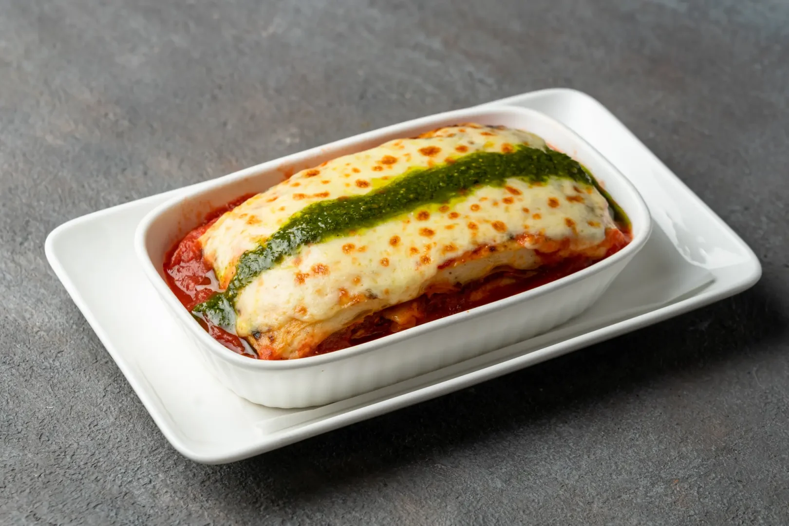 Close-up of juicy beef lasagna with golden cheese topping at Secret Oven Koh Samui