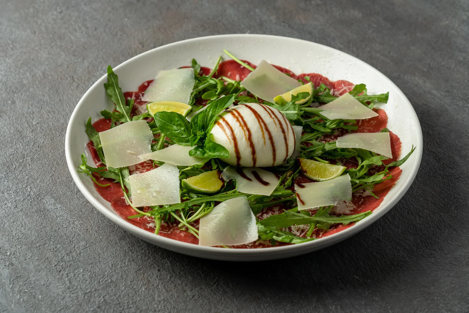 Beef carpaccio topped with creamy burrata cheese and arugula at Secret Oven Koh Samui