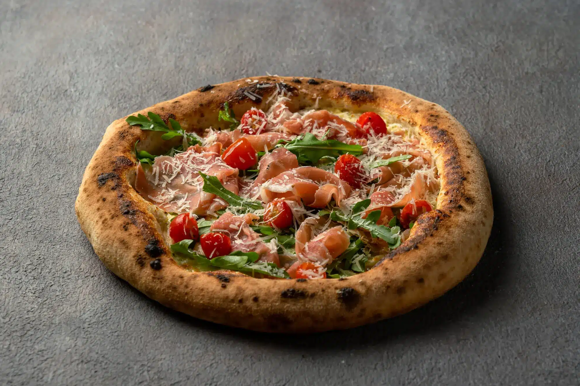 Homemade Pizza Parma with Italian prosciutto, rocket salad, and parmesan at Secret Oven restaurant